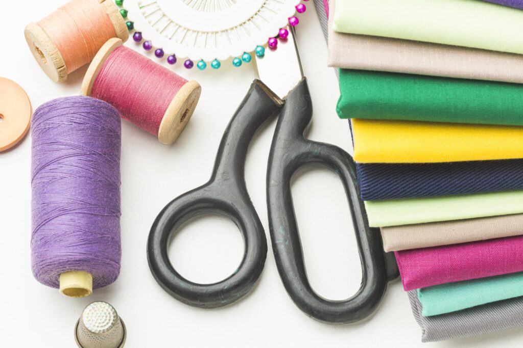 Regal Looks Redefined: Discover Premium Sherwani Styles in Hyderabad 1 top view variety fabrics with thread scissors